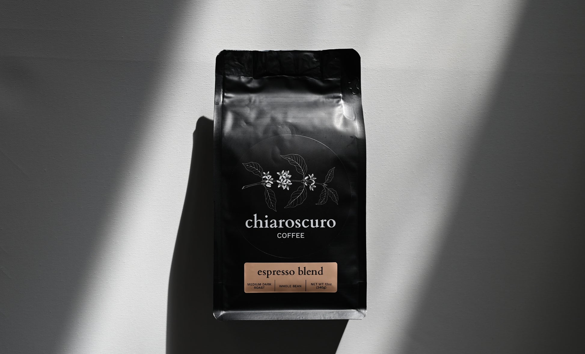 Chiaroscuro Coffee espresso blend, medium dark roast, whole bean, 12 oz package, elegant black design.